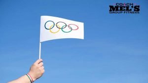Olympic flag being held against a blue sky