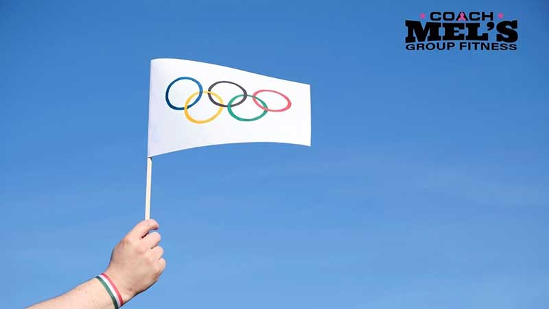 Olympic flag being held against a blue sky