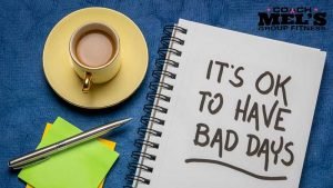Coffee cup on table with note pad stating, "It's OK to have a bad day".